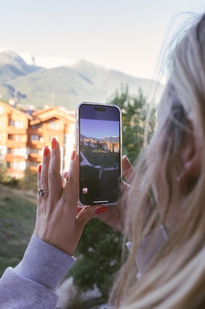 Photo une jeune fille prend une photo ou une vidéo sur son téléphone portable