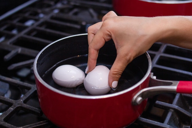 La jeune fille prépare de beaux oeufs dans la poêle pour le petit déjeuner