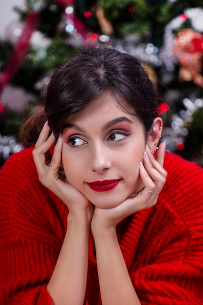 Jeune fille près de sapin de Noël