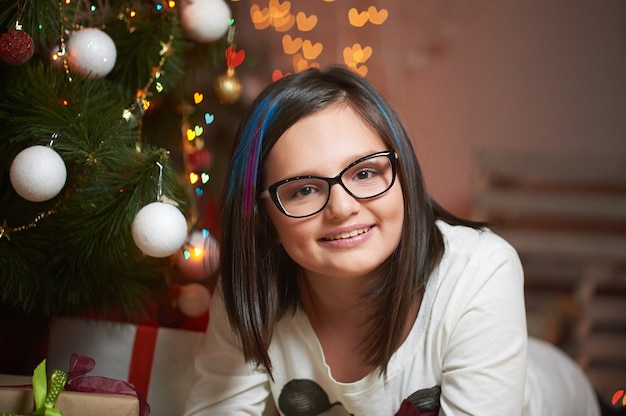 Jeune fille profitant du réveillon de Noël à la maison en souriant joyeusement.