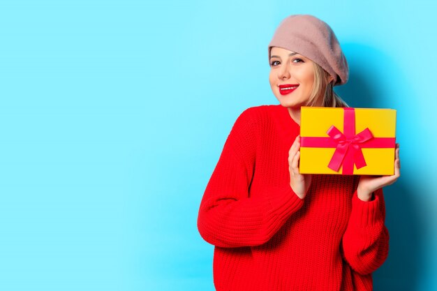 jeune fille en pull rouge avec boîte-cadeau