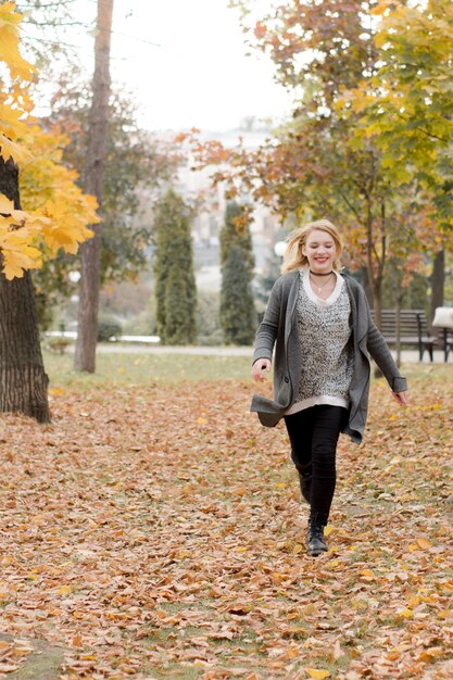 Jeune fille qui court dans le parc automne