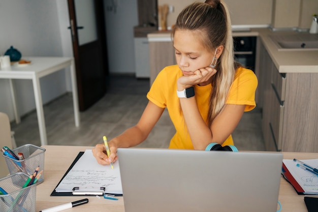 Jeune fille qui étudie à la maison