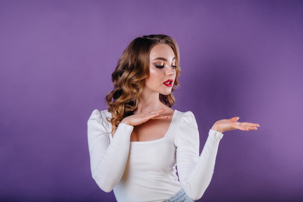 Une jeune fille qui pose en studio avec mur violet