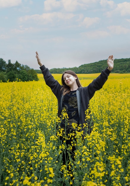 Jeune fille de race blanche sur le champ de colza jaune