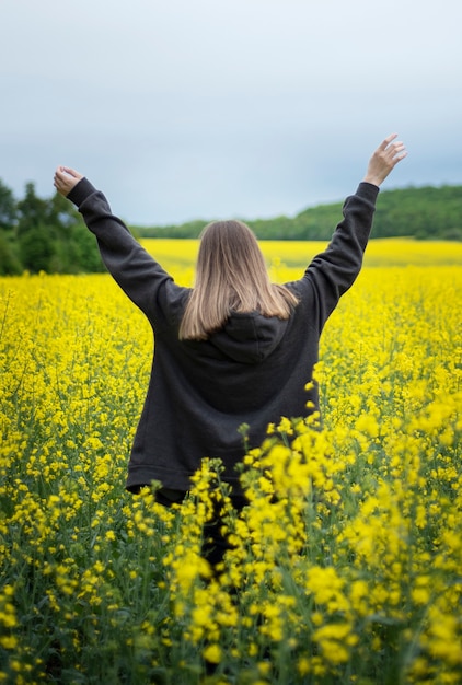 Jeune fille de race blanche sur le champ de colza jaune