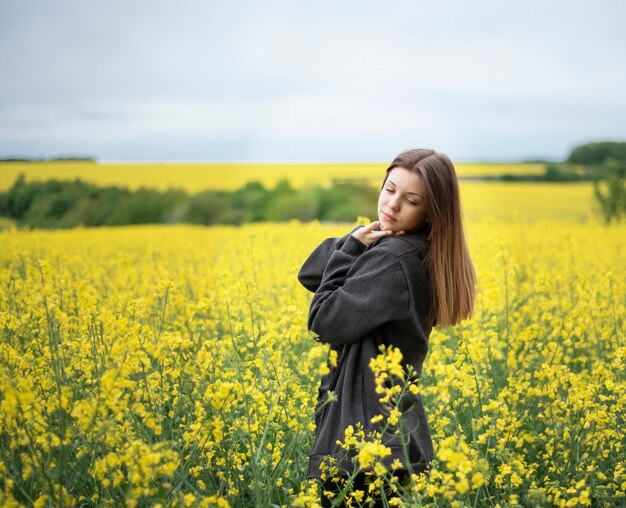 Jeune fille de race blanche sur le champ de colza jaune