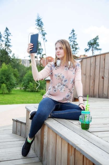 Jeune fille de race blanche à la recherche dans son téléphone mobile