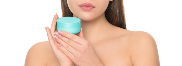 Jeune fille recadrée tenant un pot de crème pour la peau du visage isolé sur fond blanc publicité