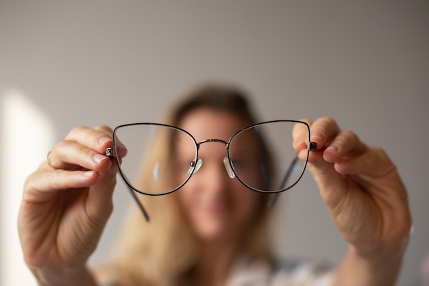 Jeune fille regarde à travers des lunettes sur les bras tendus