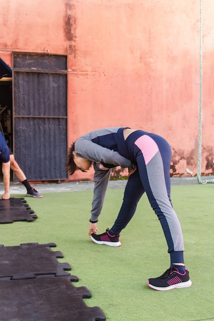 Jeune fille de remise en forme qui s'étend avant l'entraînement.