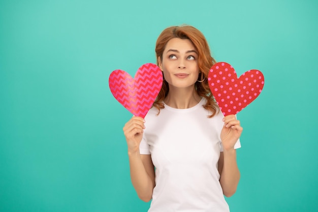 Jeune fille rêvant avec le coeur rouge sur le fond bleu