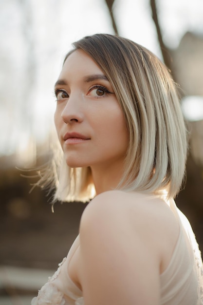 Jeune fille en robe de mariée dans la nature Portrait d'une belle fille au soleil