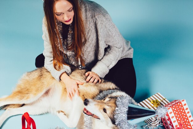 Jeune fille rousse assise sur le sol avec son gros chien, ambiance du nouvel an