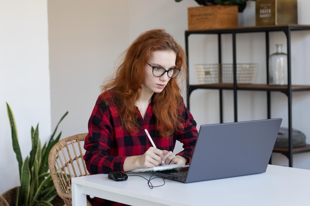 Photo jeune fille rousse travaille à distance de la maison