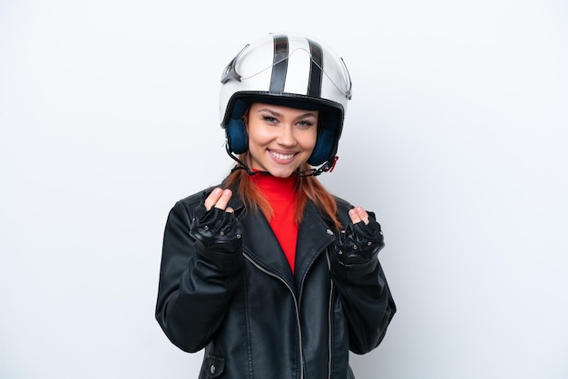 Jeune fille russe avec un casque de moto isolé sur fond blanc faisant un geste d'argent