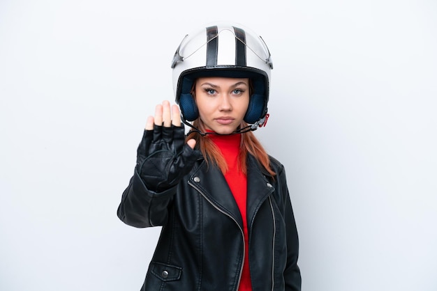 Jeune fille russe avec un casque de moto isolé sur fond blanc faisant un geste d'arrêt