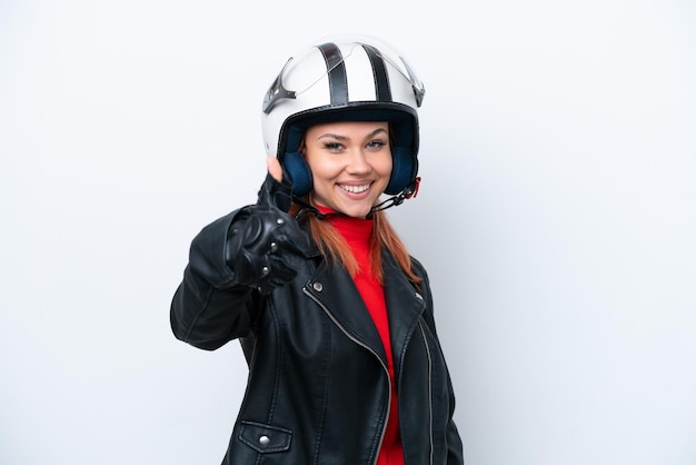 Jeune fille russe avec un casque de moto isolé sur fond blanc avec les pouces vers le haut parce que quelque chose de bien s'est produit