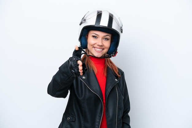 Jeune fille russe avec un casque de moto isolé sur fond blanc se serrant la main pour conclure une bonne affaire