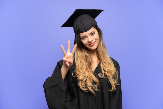 Jeune fille russe diplômée universitaire isolée sur fond blanc heureuse et comptant trois avec les doigts