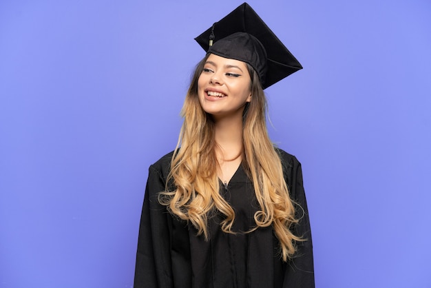 Jeune fille russe diplômée universitaire isolée sur fond blanc en pensant à une idée tout en levant les yeux