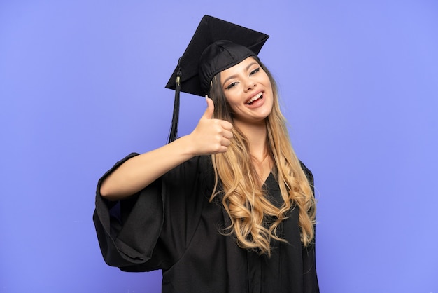 Jeune fille russe diplômée universitaire isolée sur fond blanc avec les pouces vers le haut parce que quelque chose de bien s'est produit