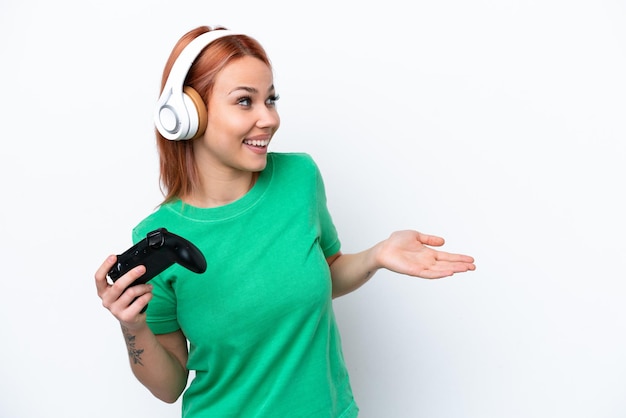 Jeune fille russe jouant avec un contrôleur de jeu vidéo isolé sur fond blanc avec une expression surprise tout en regardant de côté