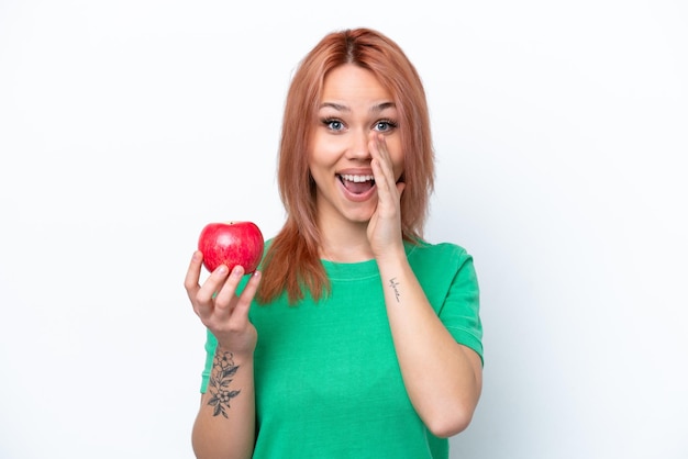 Jeune fille russe avec une pomme isolée sur fond blanc criant avec la bouche grande ouverte