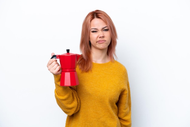 Jeune fille russe tenant une cafetière isolée sur fond blanc avec une expression triste