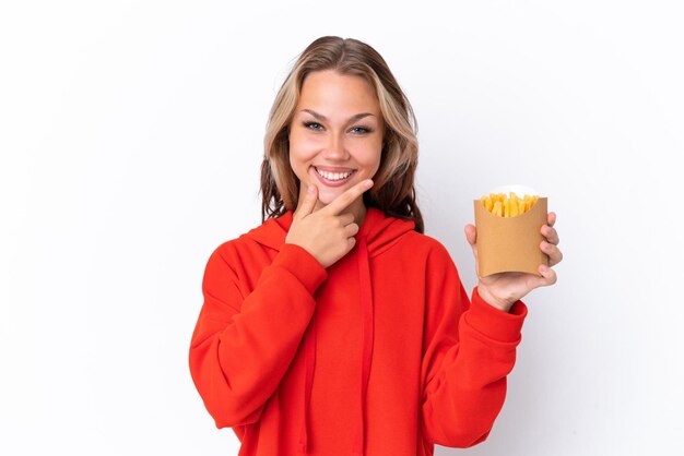 Jeune fille russe tenant des chips frites isolés sur fond blanc heureux et souriant