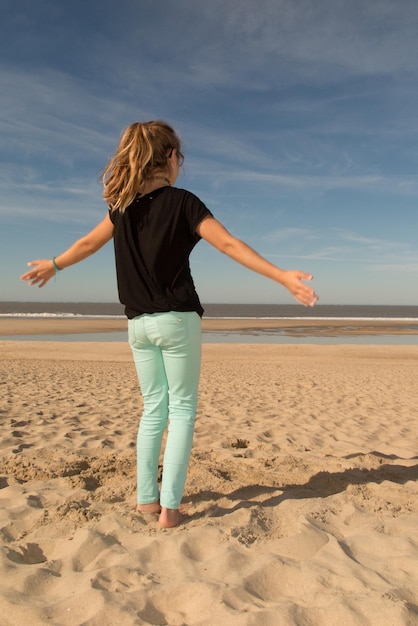 Jeune fille s'amusant sur le sable de la plage