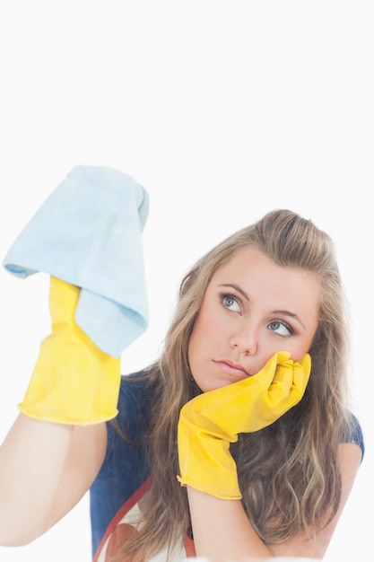 Photo jeune fille s'ennuie dans les gants jaunes à l'aide de chiffon