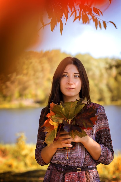 La jeune fille se bouchent dans le feuillage d'automne