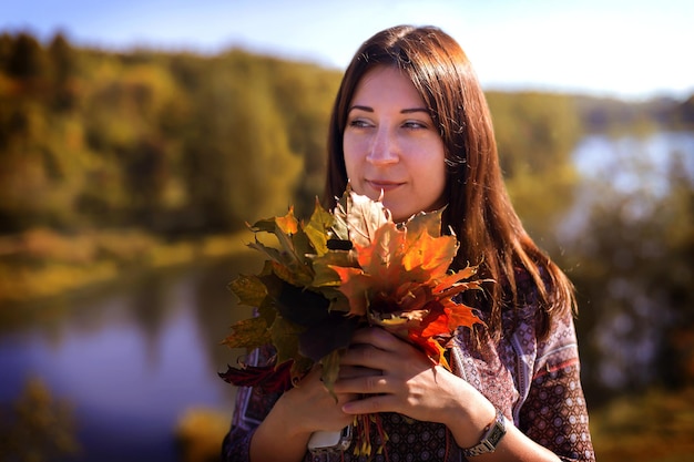 La jeune fille se bouchent dans le feuillage d'automne