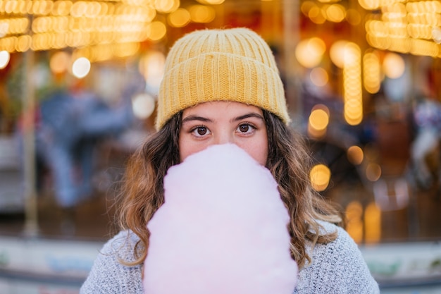 Jeune fille se cachant derrière la barbe à papa