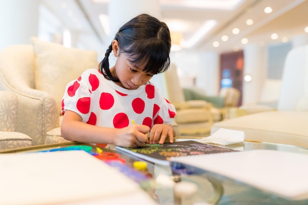 La jeune fille se concentre sur le livre.