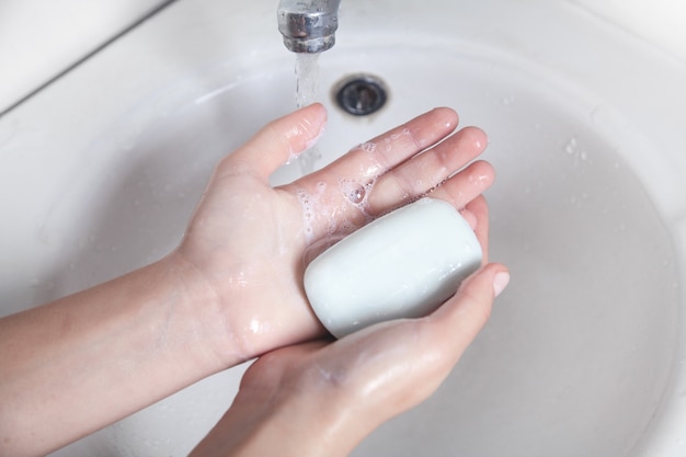 Jeune fille se laver les mains avec un savon. Hygiène