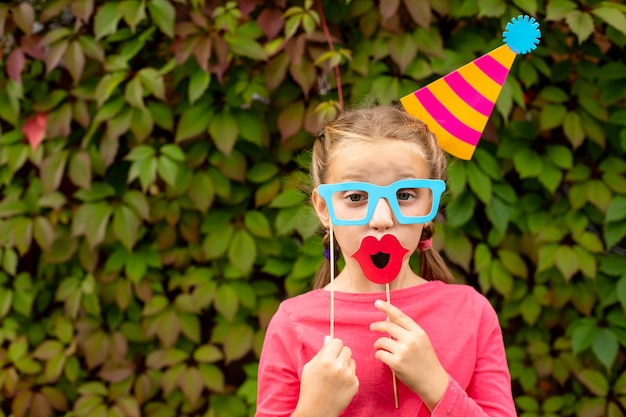 Jeune fille se prépare pour la fête d'anniversaire avec des accessoires de photomaton.