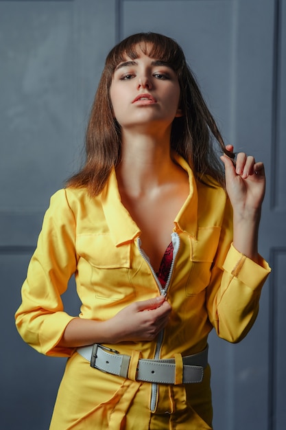 Une jeune fille séductrice dans un vêtement jaune déboutonné