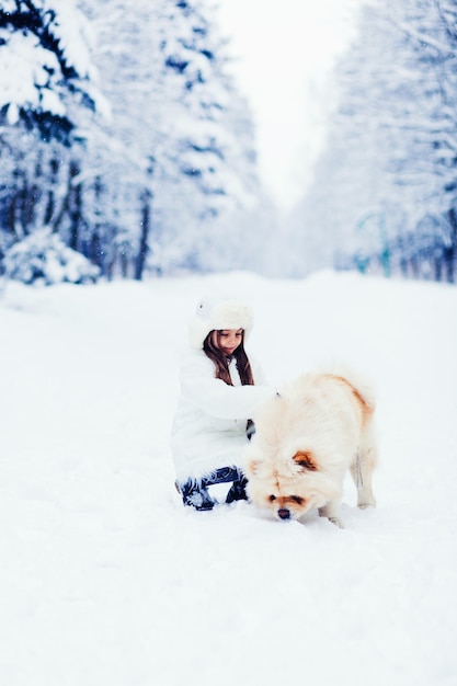 Jeune fille avec son chien, chow chow, en plein air