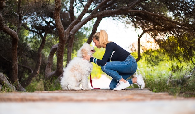 Jeune fille avec son chien dans un parc