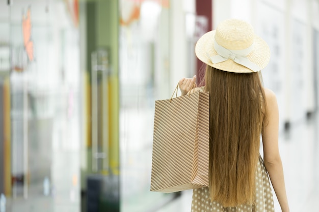 Photo jeune fille sur son dos avec un sac brun