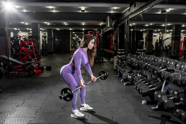 Jeune fille soulevant des poids dans la salle de gym. concept de mode de vie sain