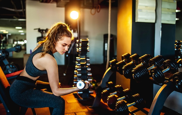 Jeune fille, soulever des poids dans la salle de gym