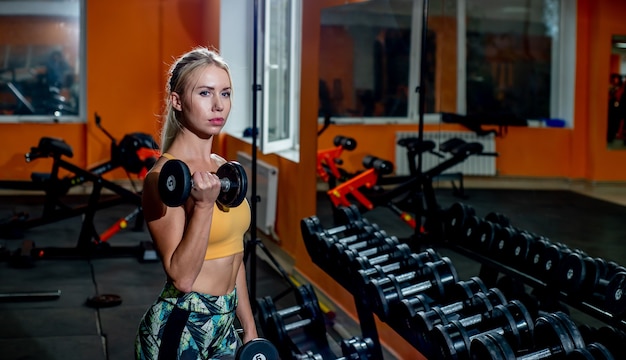 Jeune fille soulever des poids dans la salle de gym