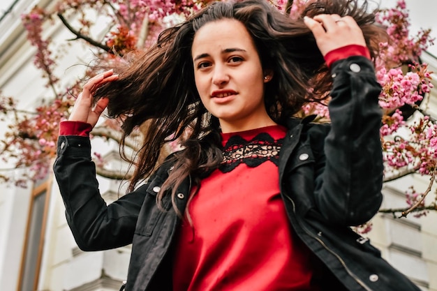 Jeune fille souriante appréciant les arbres de printemps inflorescence