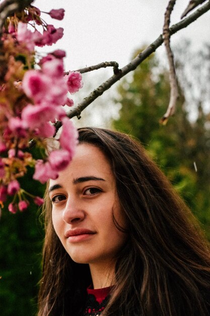 Jeune fille souriante appréciant les arbres de printemps inflorescence