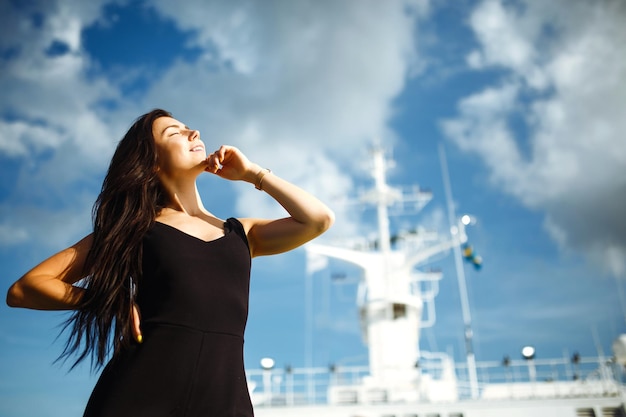 Jeune fille souriante sur un ferry Jeune femme assise sur le pont du ferry pendant les vacances d'été