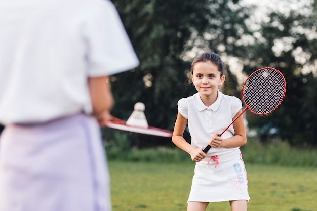 Jeune fille souriante jouant au badminton avec son amie