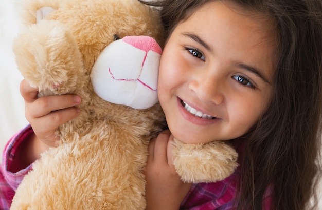 Photo jeune fille souriante avec un jouet en peluche